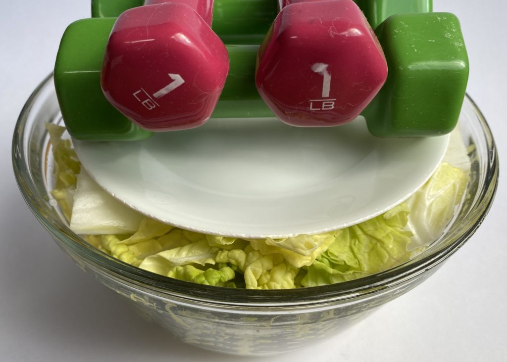 place a plate and weights on top